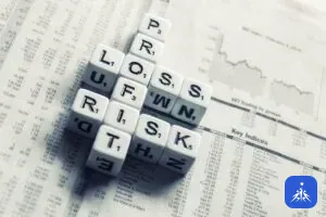 Finansal tablo sayfası üzerinde “profit”, “loss” ve “risk” kelimelerini oluşturan harf küpleri